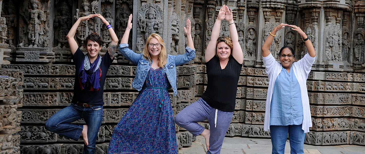 Group of people in India making O-H-I-O in front of a temple