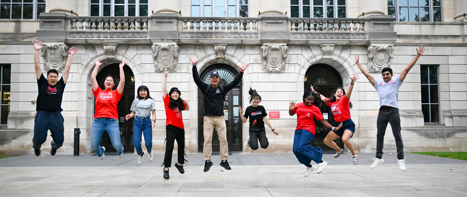 Students jumping in front of Thompson Library