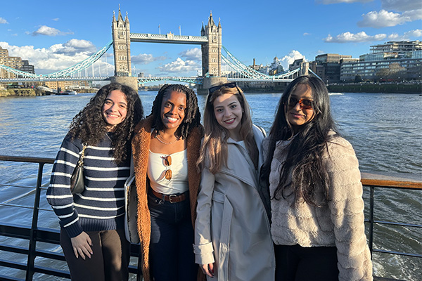 Four students posing overlooking the London Bridge and London River