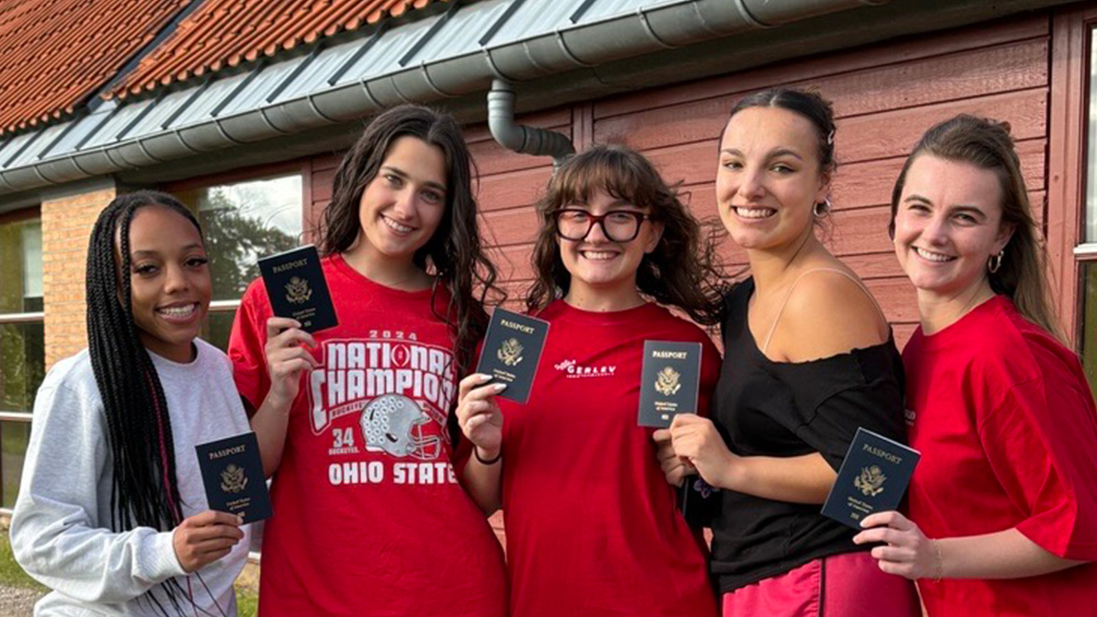 Students holding up passports. 