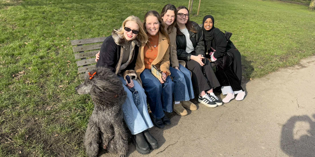 Five women seated on a bench