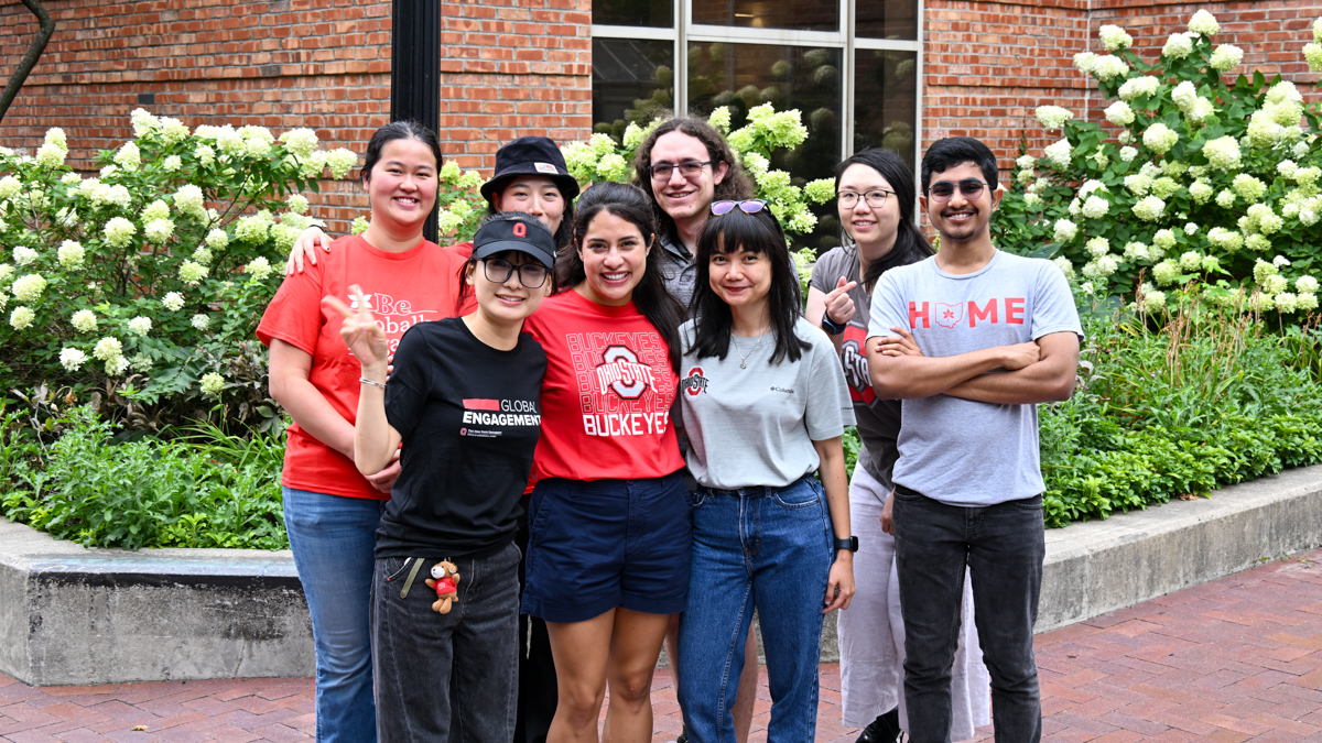 Group of student wearing various Ohio State clothes outside of building.