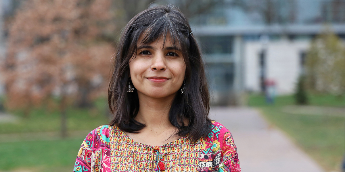 Woman wearing colorful top outside.