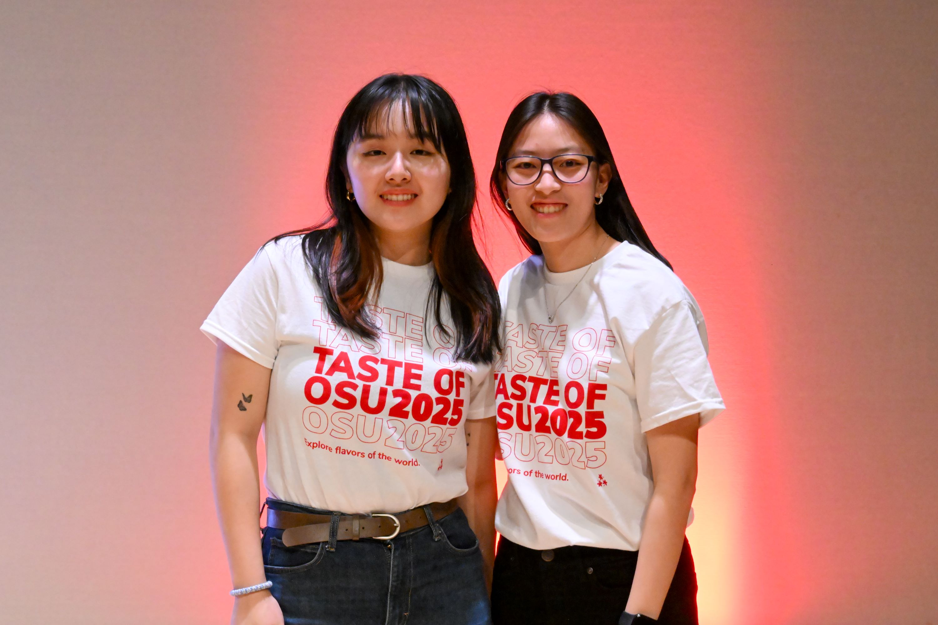 Two students standing on stage wearing Taste of OSU 2025 t-shirts