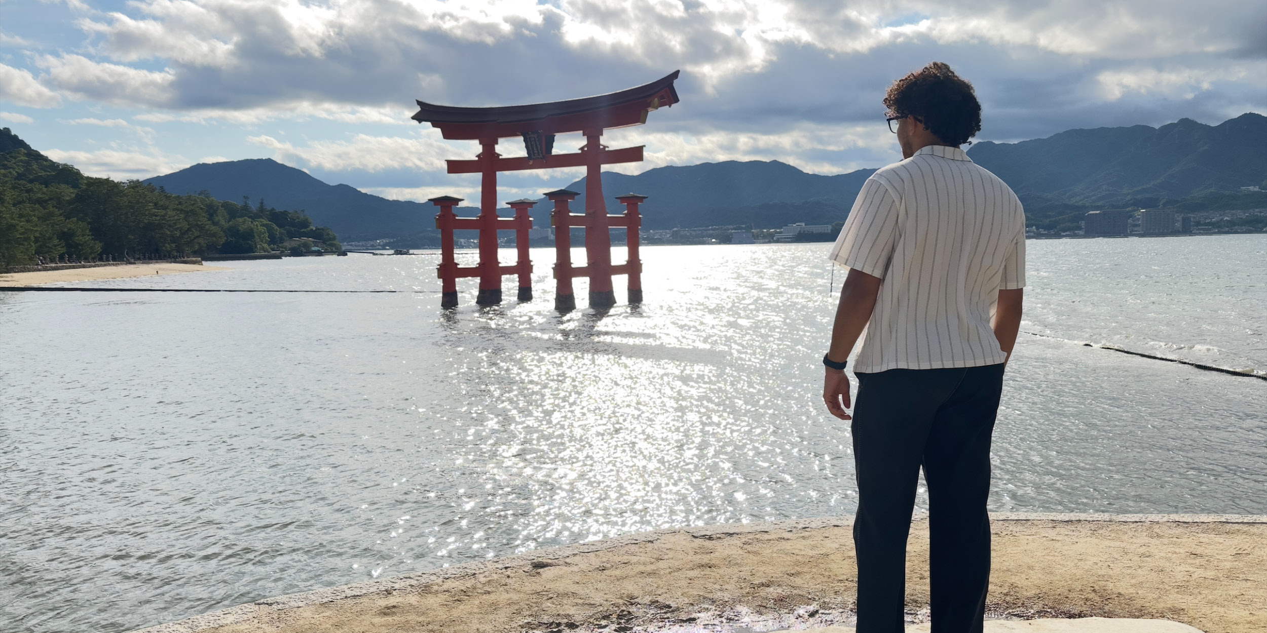 student standing on the shore looking at structure