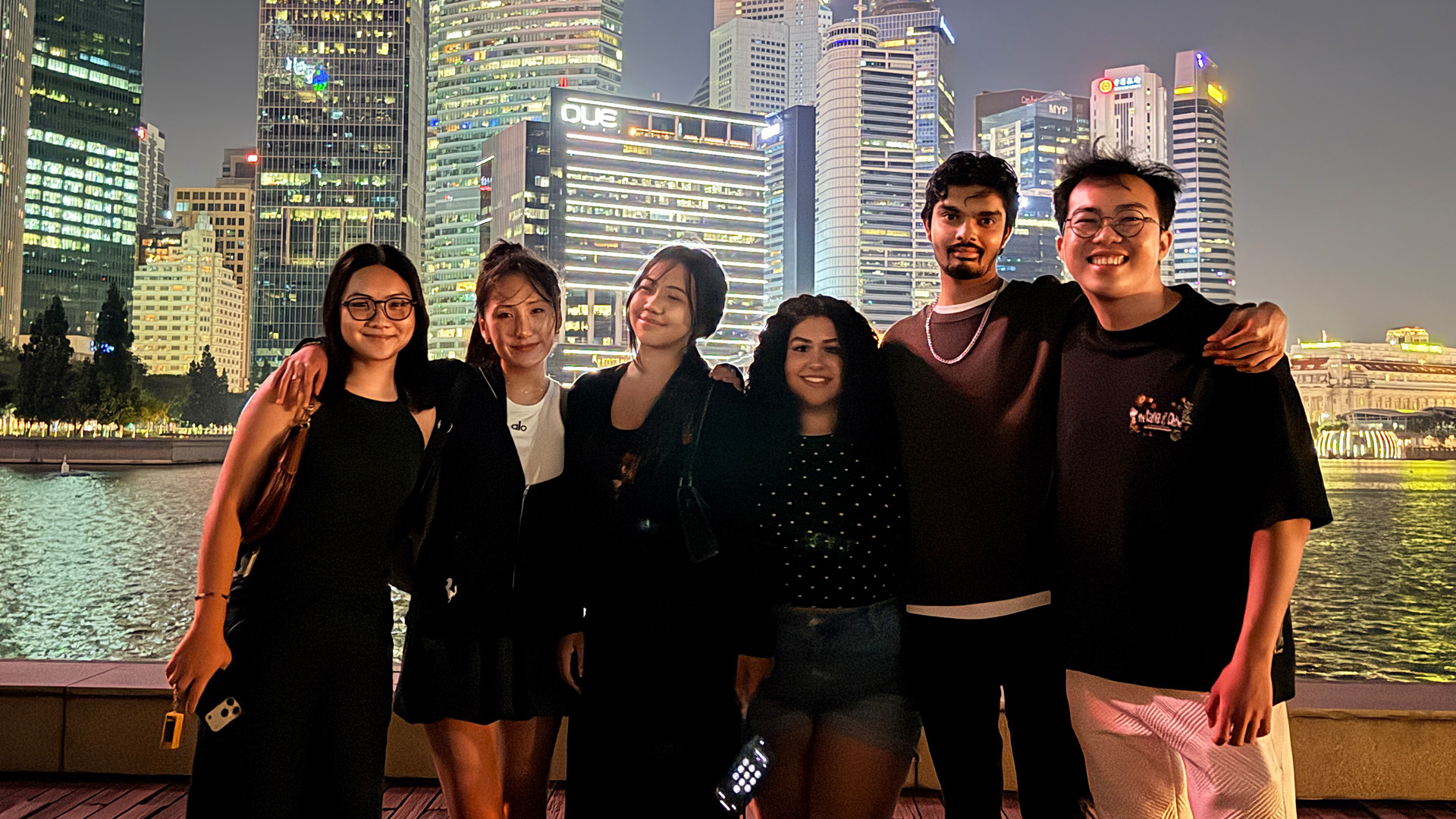 Students posing at night near skyline