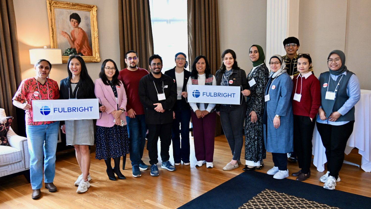 Men and women pose for group photo holding two Fulbright banners.
