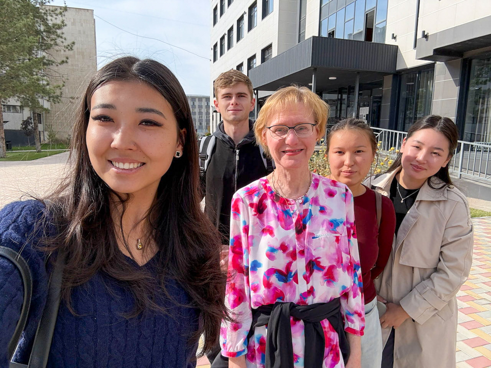 Five people pose for selfie outside.