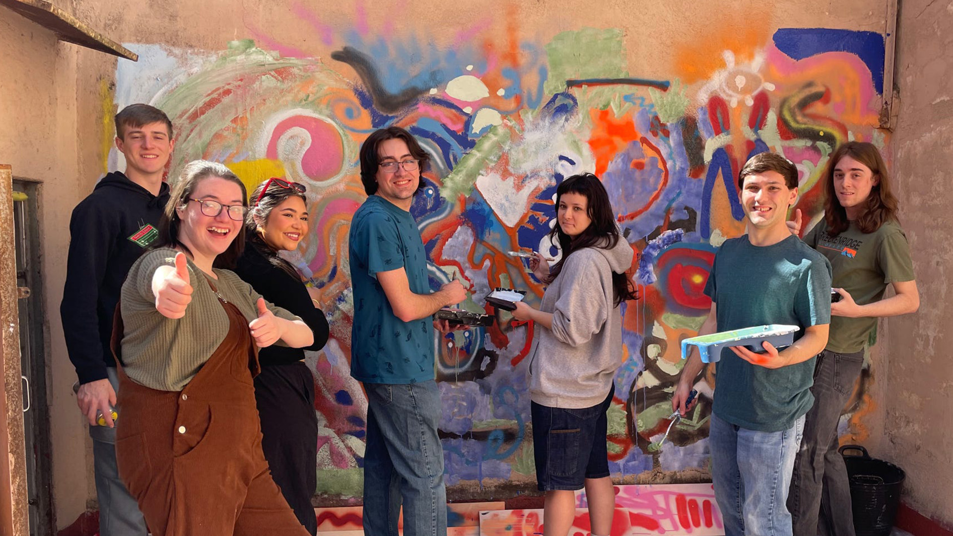 Students posing near an artboard