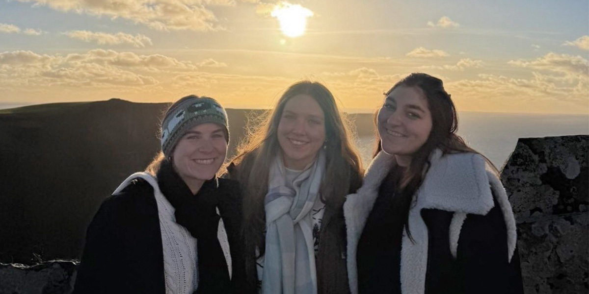 Students posing over mountainside