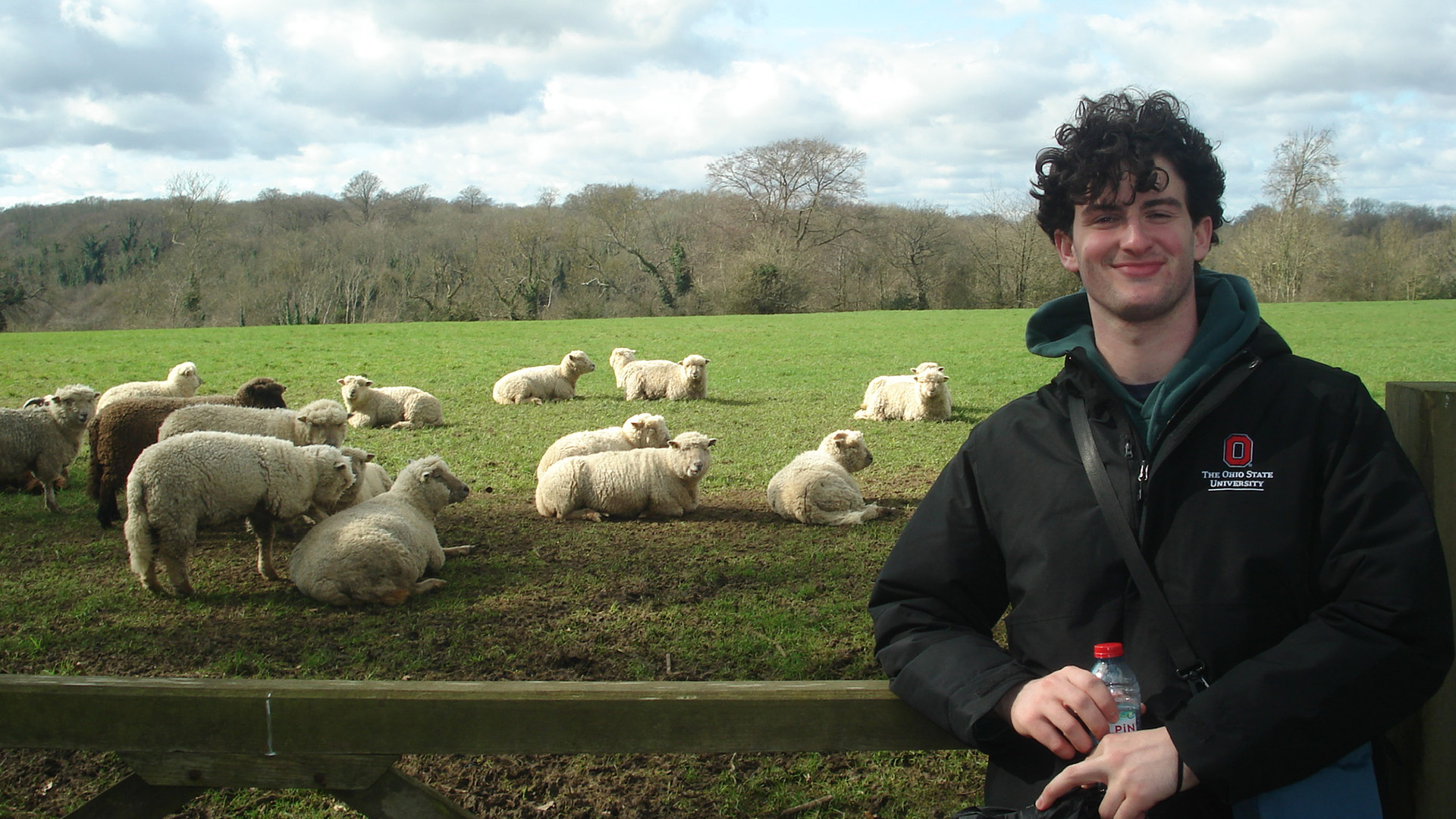 student posing with sheep