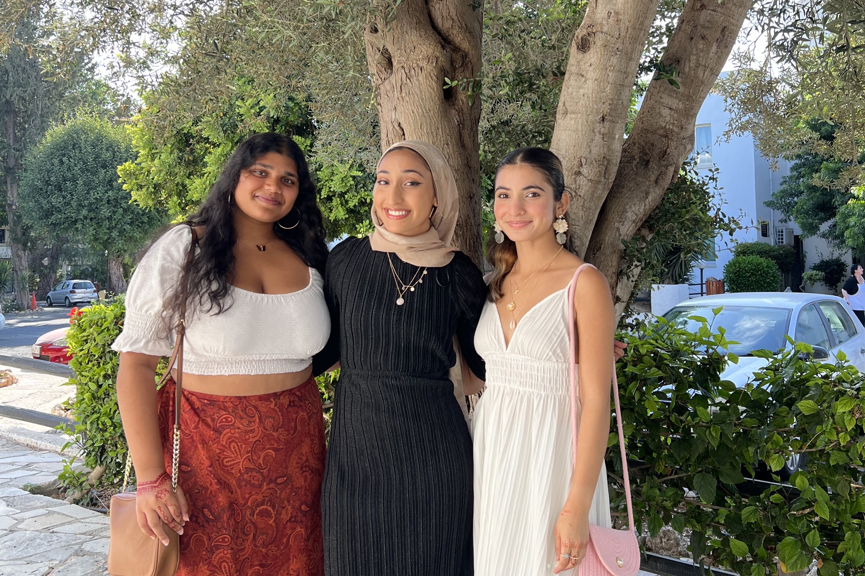 Three young women pose in front of trees in Cyprus