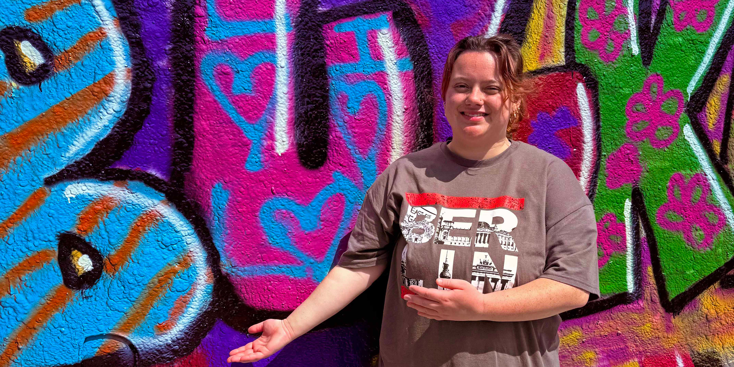 student in front of grafitti wall