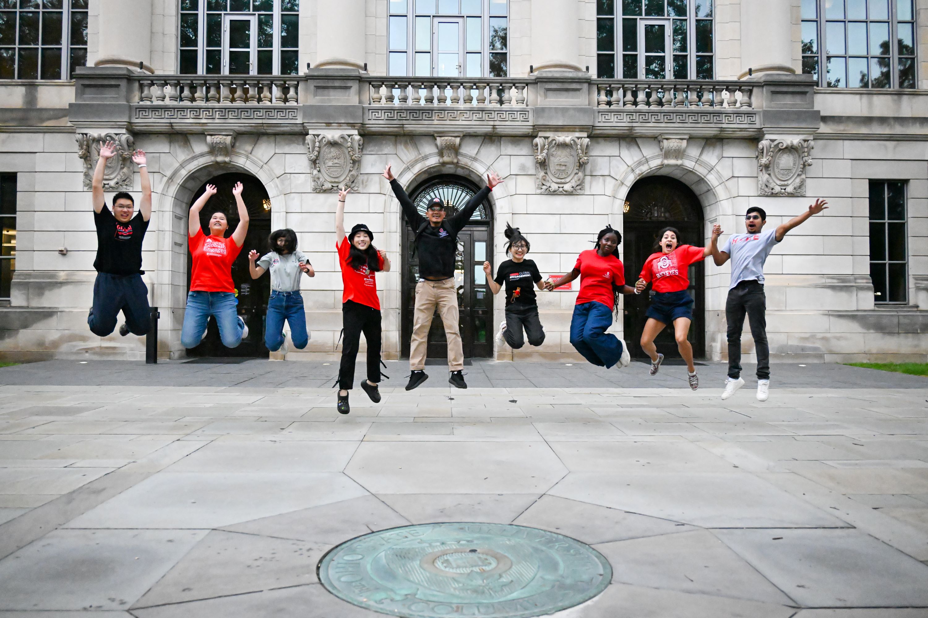 Orientation leaders jumping in front of Thompson Library