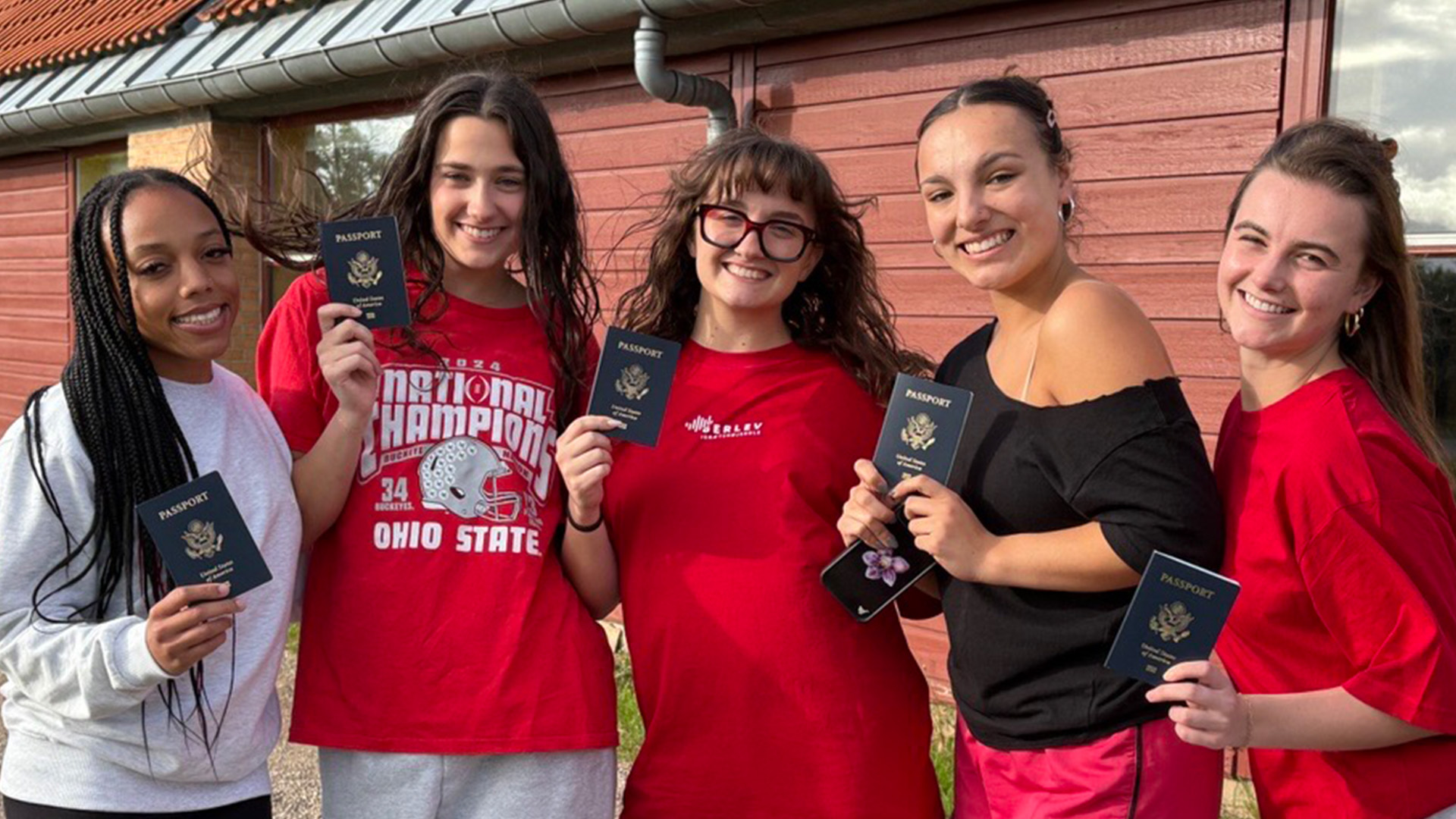 students holding up passports