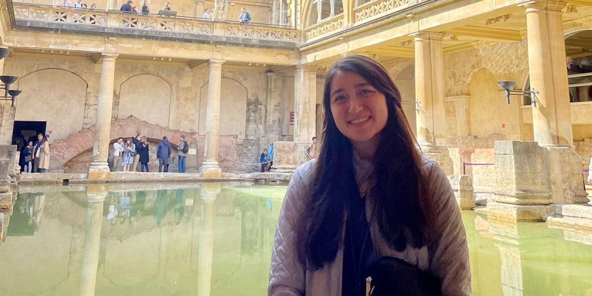 Female with Roman baths in background.