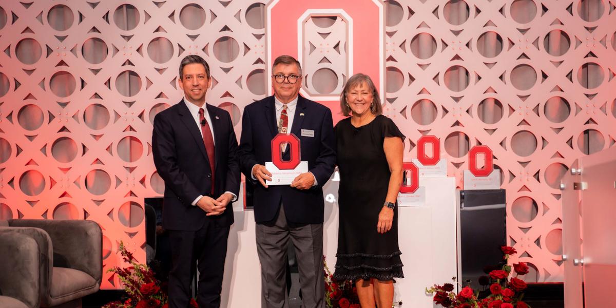 Three people on stage with Ohio State backdrop