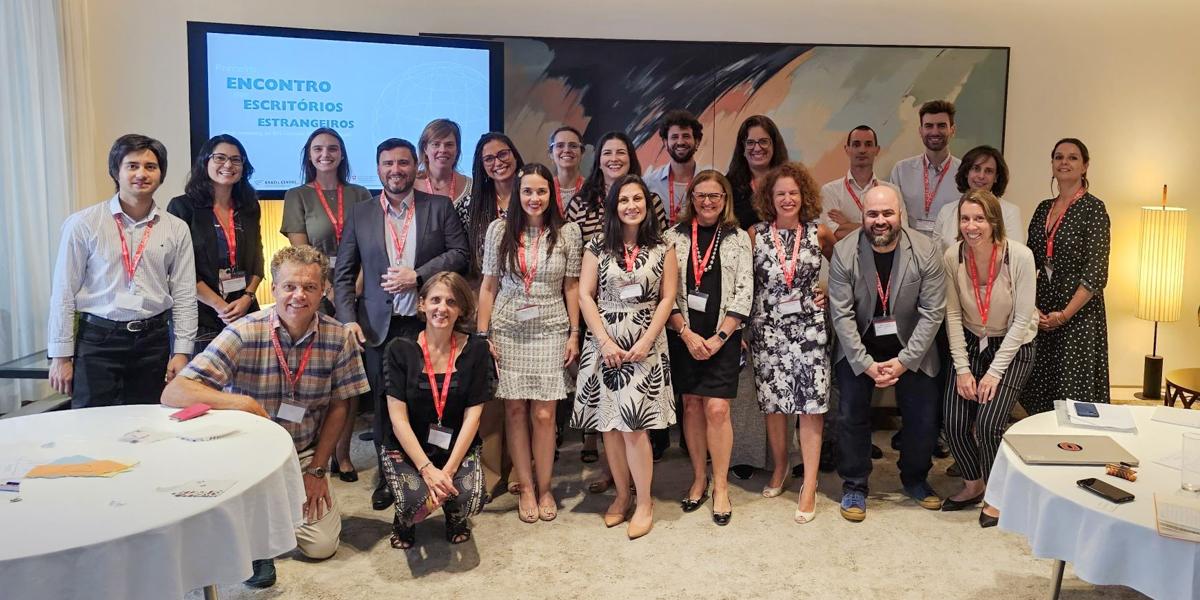 Two rows of professional staff pose in front of a screen.