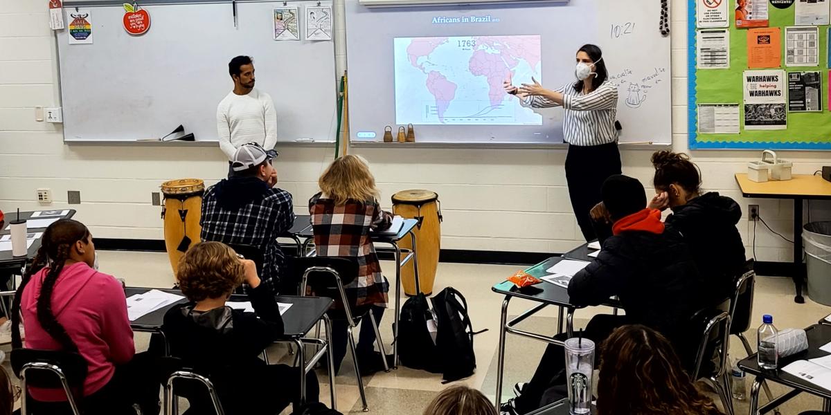 Women standing in front of board teaching a class about Brazil