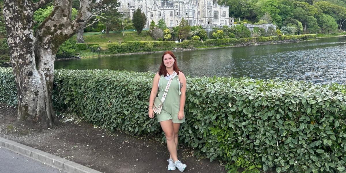 student standing in front of a castle