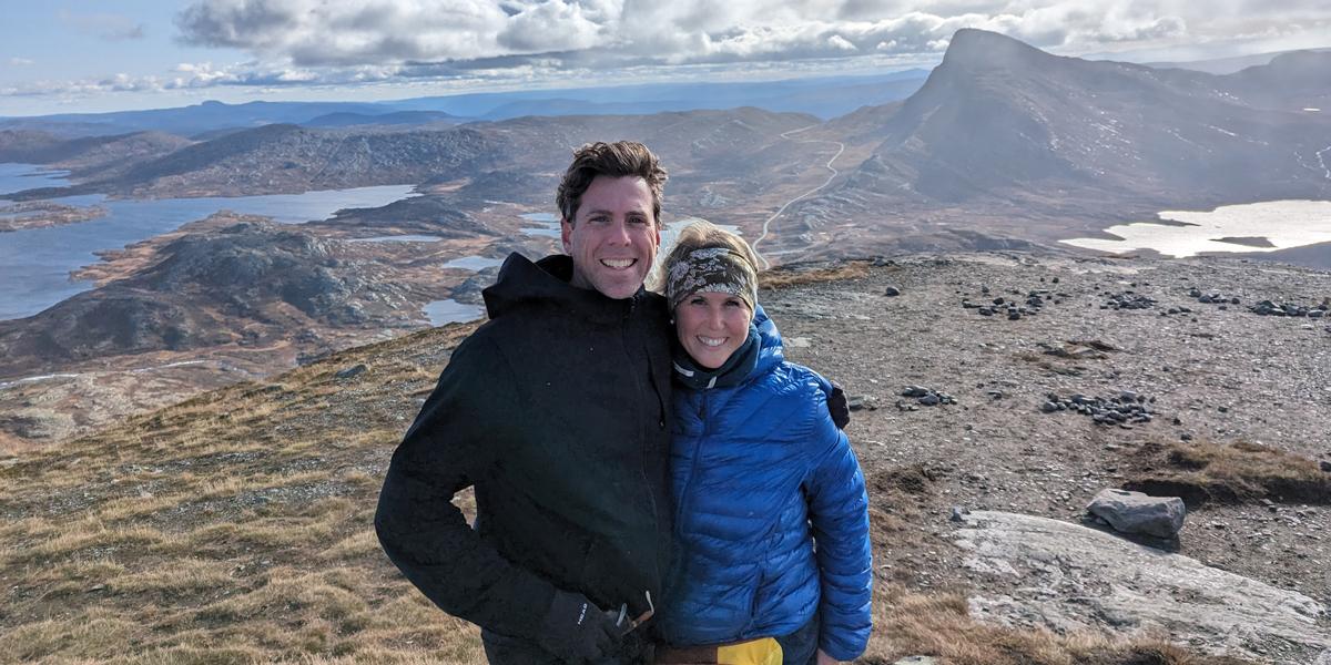 Two people at the top of a mountain range