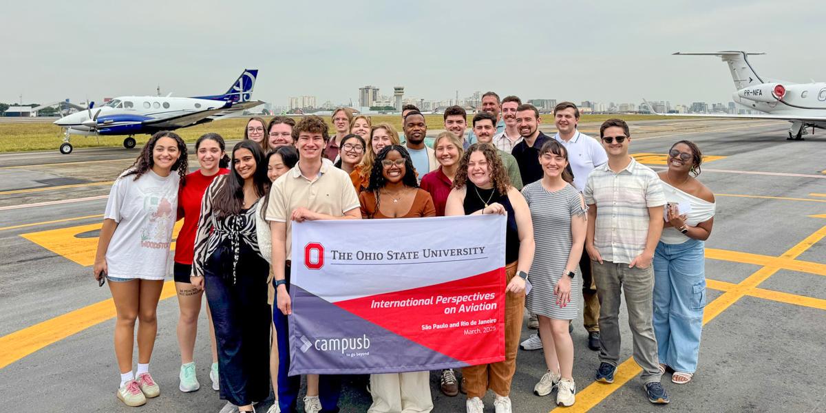 Group holding flag in front of planes