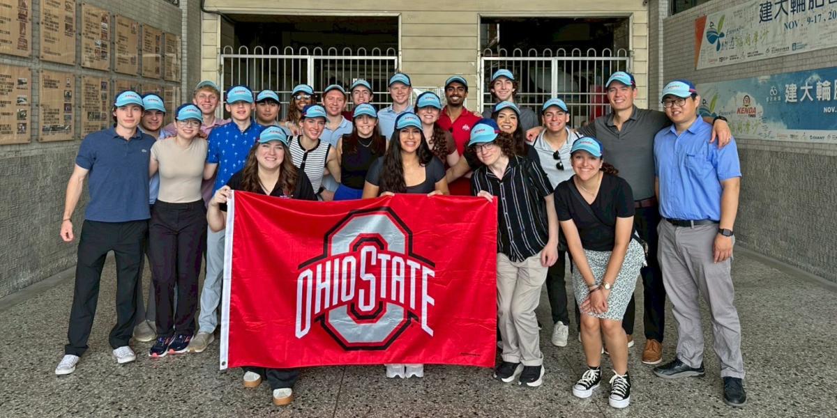 students with an ohio state flag in front of business