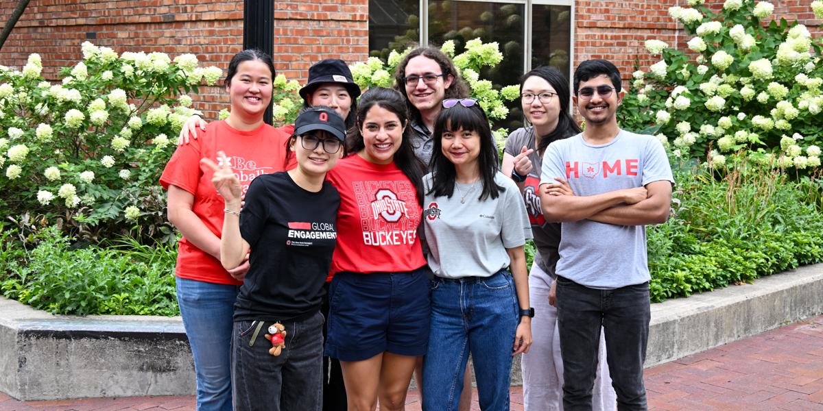 Group of student wearing various Ohio State clothes outside of building.