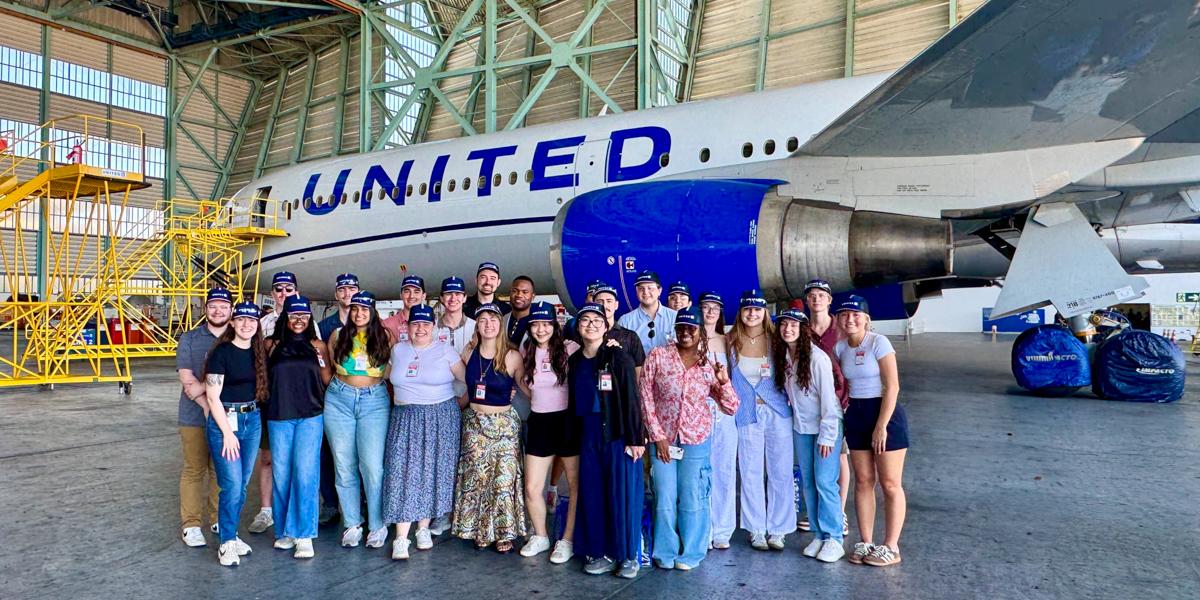 Students pose in front of United plane