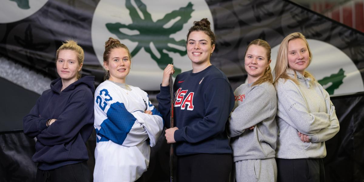 Five hockey players pose standing shoulder to shoulder