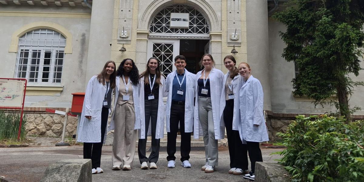 People in lab coats standing outside medical center