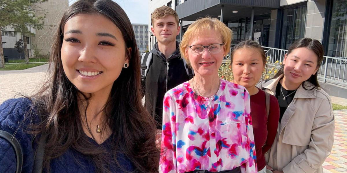 Five people pose for selfie outside.