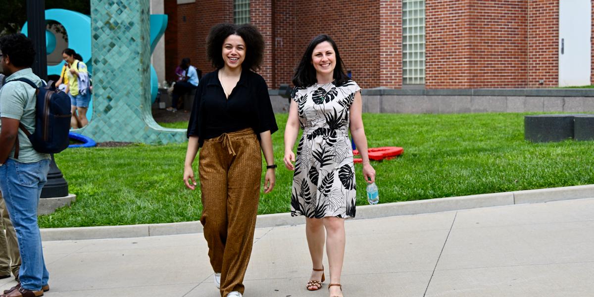 Two woman walk on university campus.
