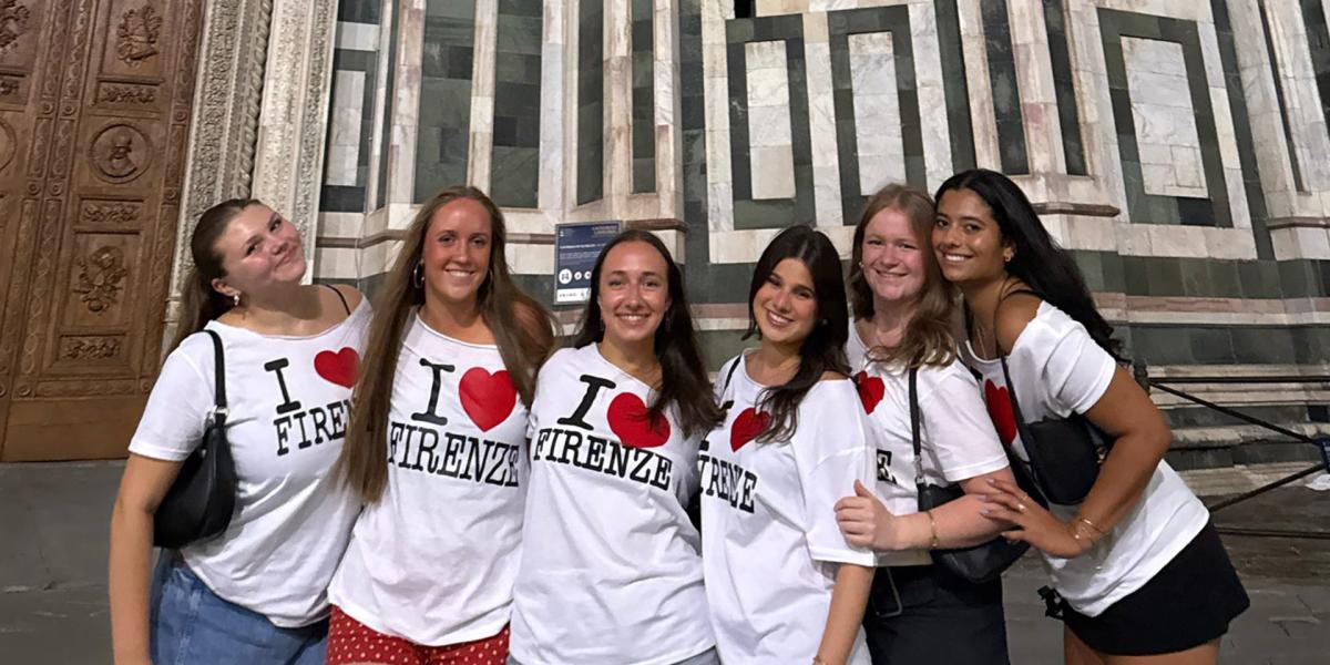 Students in matching shirts in front of building