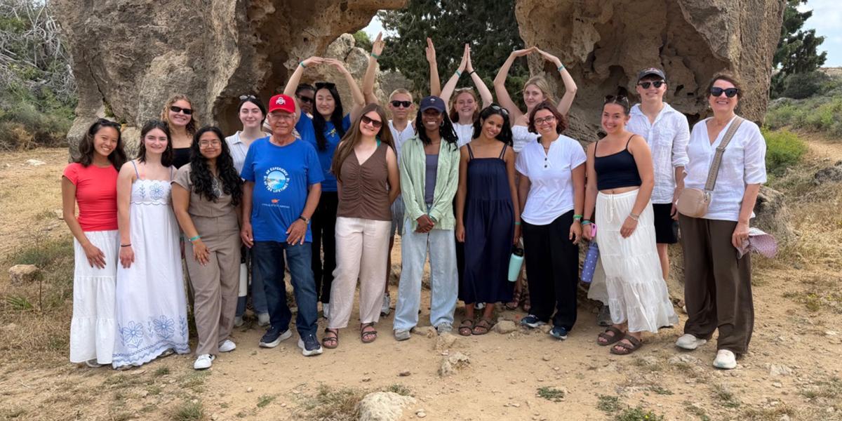 Students doing OHIO near large rock