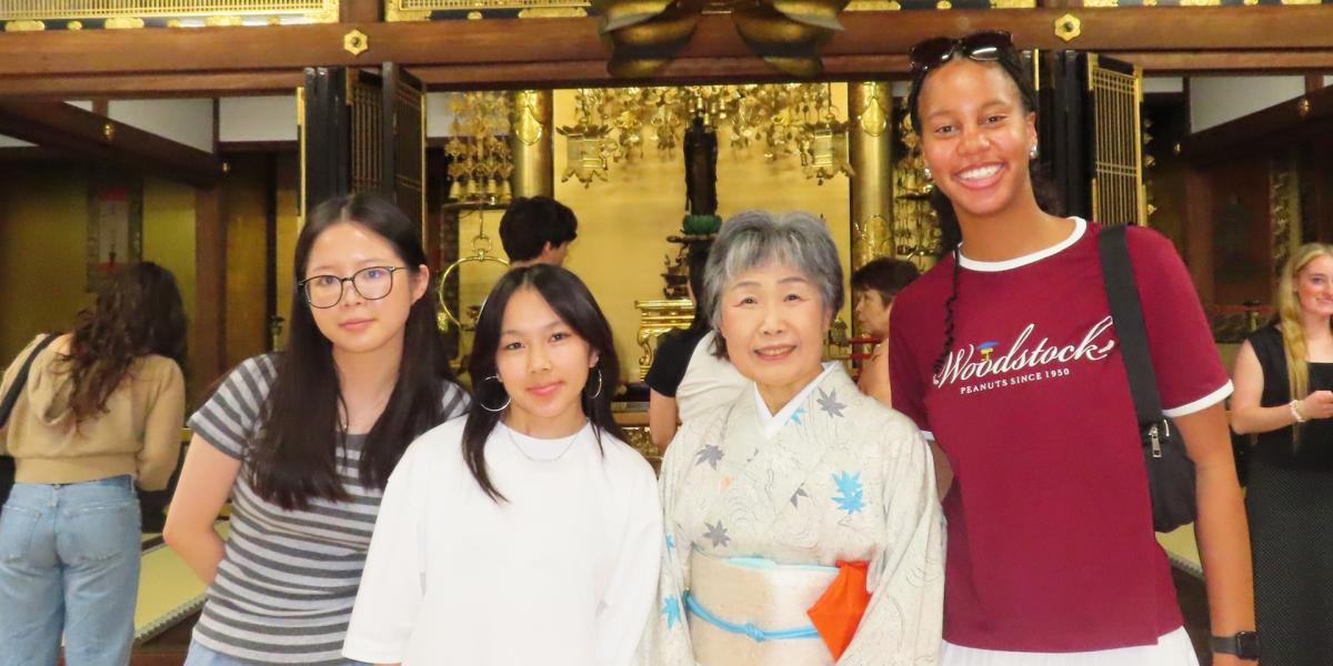 Four people in front of building in Japan