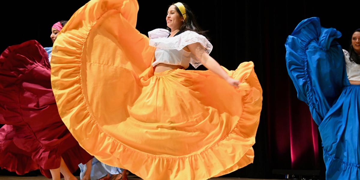 Dancers on stage at Taste of OSU in colorful costumes