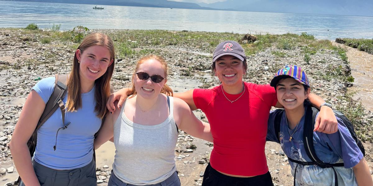 Students posing near a lake