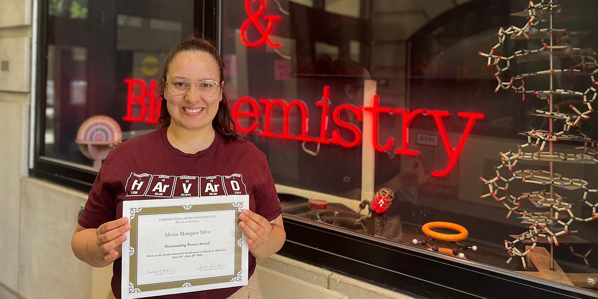 Alexia holding her certificate for "Outstanding Poster Award."