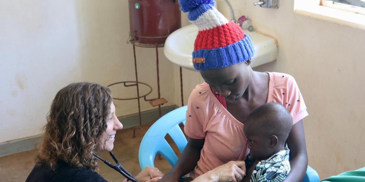 Pediatrician checks the heartbeat of a child in a rural hospital