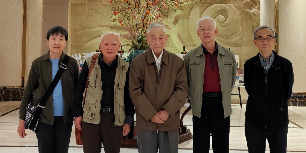 Five individuals post in a restaurant lobby