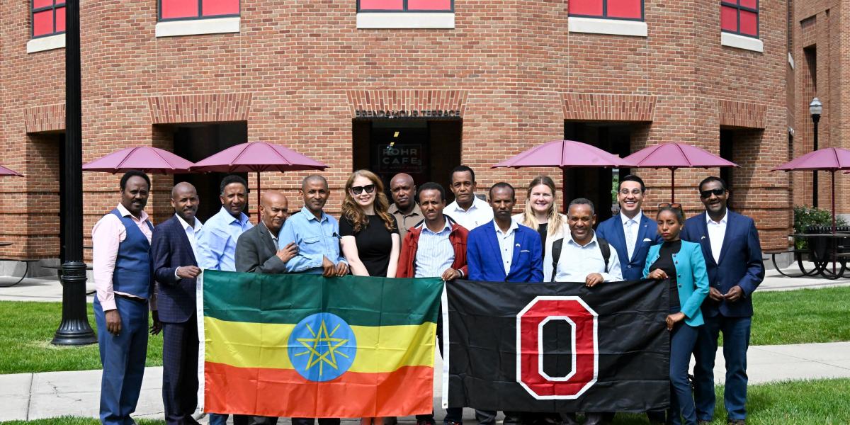 Group of Ethiopian leaders and Ohio State administrators hold the Ethiopian flag and the Ohio State flag in front of the Fisher College of Business