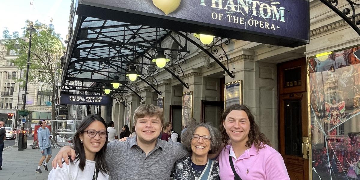 Four students in London in front of a theatre