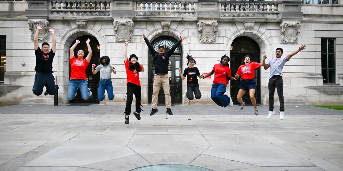 Orientation leaders jumping in front of Thompson Library