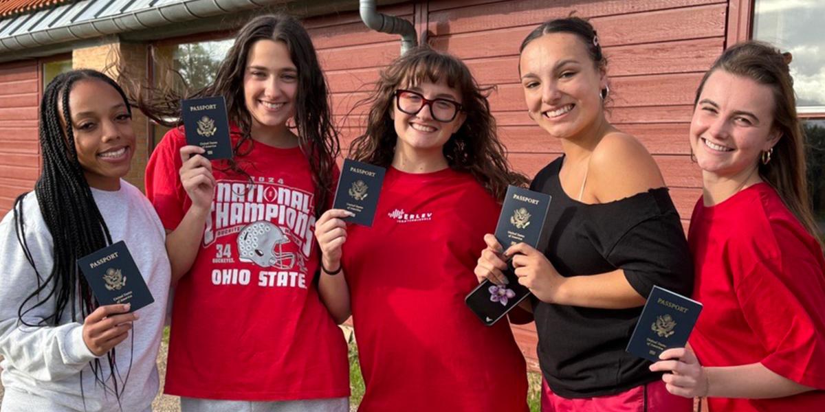 students holding up passports