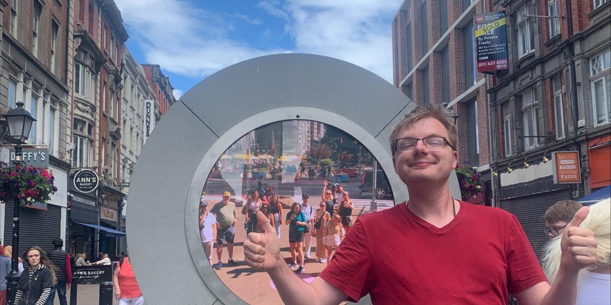 Young man poses in front of Irish sculpture