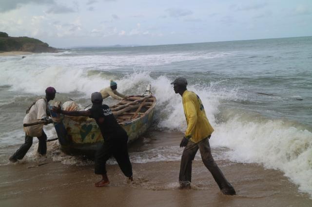 4 men with boat in water