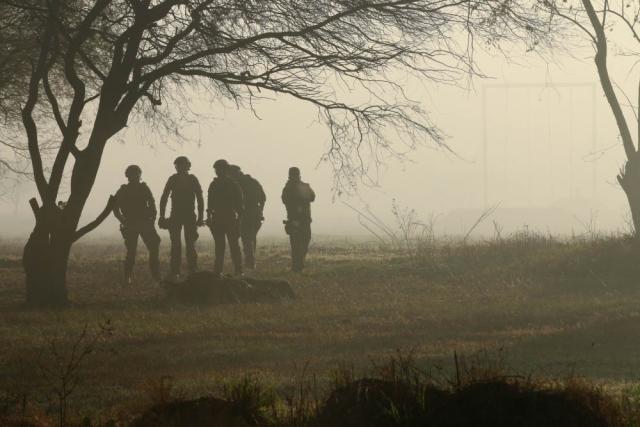 Group of people walking on foggy field