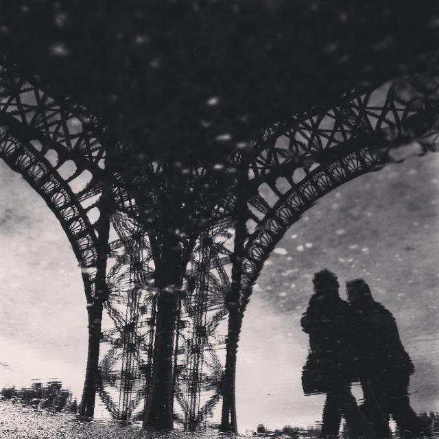 two people walking underneath Eiffel tower 