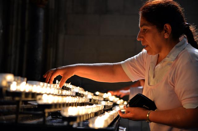 Woman in front of lines of candles